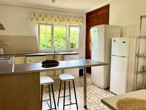 een keuken met een aanrecht en een koelkast bij 4 bedrooms house with enclosed garden and wifi at Bastian 3 km away from the beach in Raíces