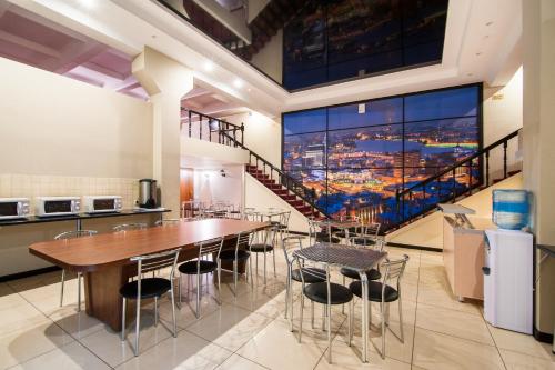 un comedor con mesa y sillas y una escalera en Express Hotel&Hostel, en Kazán