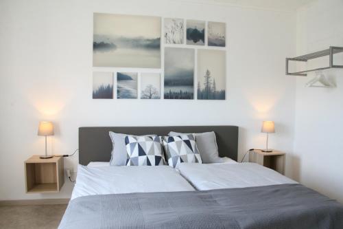 1 dormitorio con 1 cama grande y 3 cuadros en la pared en Haus Luna, en Bütgenbach