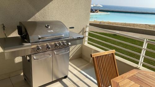 a grill on a balcony with a view of the ocean at San Alfonso del Mar Puerto del Sur in Algarrobo