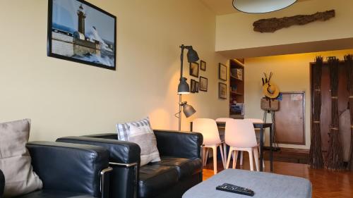 a living room with a couch and a table and chairs at Apartamento vista Douro e Mar in Porto