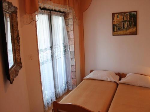 een slaapkamer met een bed en een raam bij Apartment in Kali with sea view, balcony, air conditioning, Wi-Fi (4566-3) in Kali