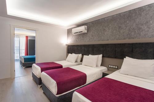a hotel room with two beds and a window at TAMARA Business Otel in Antalya