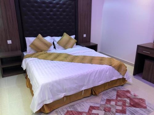 a bedroom with a large bed with a large headboard at طيف للأجنحة الفندقية in Al Kharj