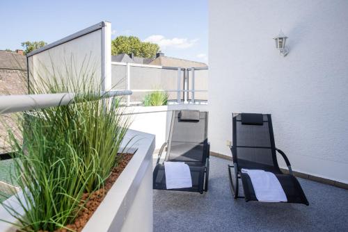 two chairs on the balcony of a building at Rheinhotel Rüdesheim - Wellness in Rüdesheim am Rhein