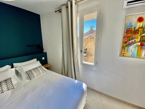 a bedroom with a white bed and a window at La Maison des Vendangeurs - TABLE D'HÔTES le soir du jeudi au dimanche- Jacuzzi - Balnéo SPA - ACCES PISCINE pour toutes les chambres sauf STUDIO COQUET- Piscine de mai à mi-octobre in Martignargues