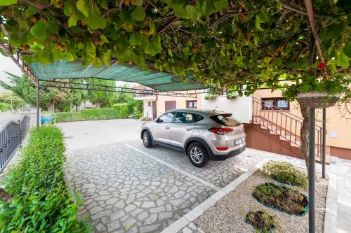 a silver car parked in a driveway next to a house at Apartment Casa Banko in Rovinj