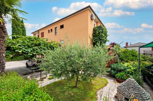 a garden with a tree and a building at Apartment Casa Banko in Rovinj