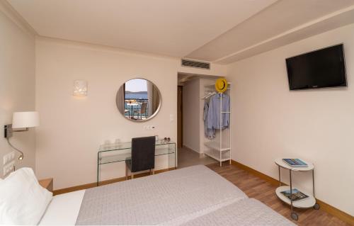 a bedroom with a bed and a flat screen tv at Karalis City Hotel in Pylos