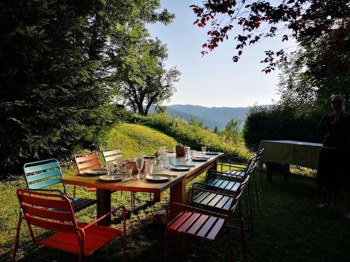 a long wooden table with chairs around it at Maison Le ROZET in Les Gras