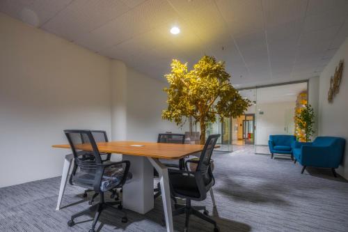 an office meeting room with a wooden table and chairs at The Address Palace Apartments in Dammam