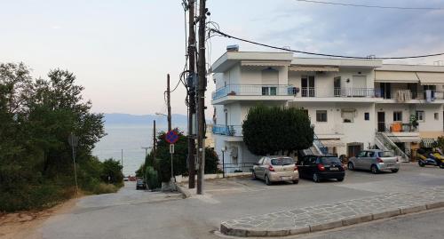 a building with cars parked in a parking lot at Alma Maisonette in Kavala