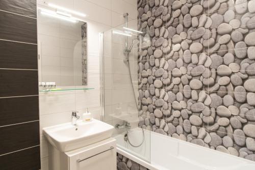 a bathroom with a sink and a shower with a mirror at East Side Living & Terrace in Braşov