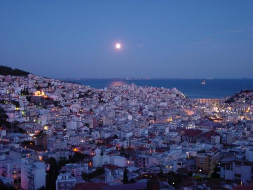 a view of a city at night with the moon at Alma Maisonette in Kavala