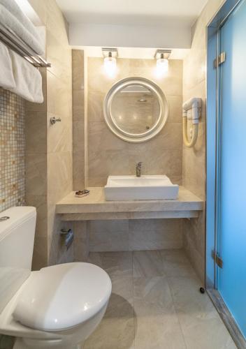 a bathroom with a white toilet and a sink at Karalis City Hotel in Pylos