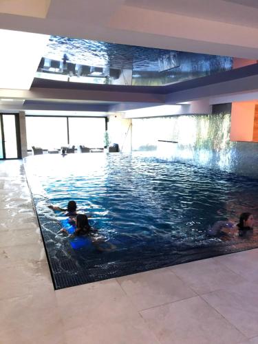 a swimming pool with two people in the water at Zen apartman in Kopaonik