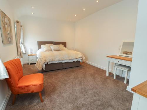 a bedroom with a bed and a chair and a desk at Flat 1 in Prestatyn