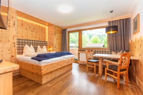 a bedroom with a bed and a table and chairs at Apartment Gästehaus Luggau in Rauris