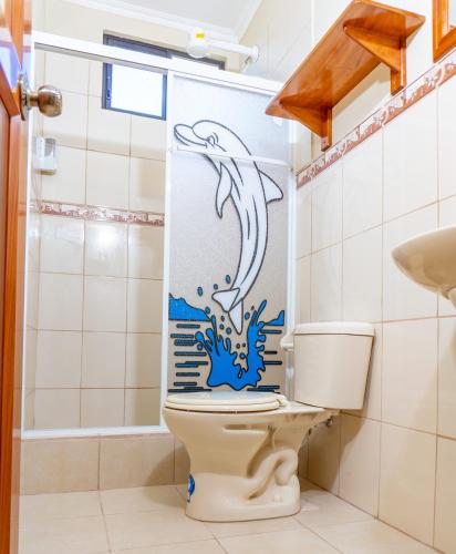 a bathroom with a toilet with a dolphin shower curtain at Cucuve Eco Hostal in Puerto Baquerizo Moreno