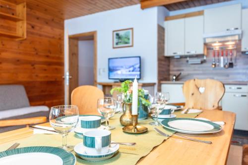 a dining room table with plates and wine glasses at Apartment Gästehaus Luggau in Rauris