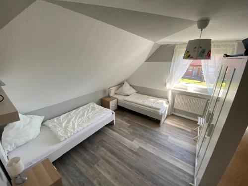 Petersdorf auf FehmarnにあるFerienwohnung-Wildblumeのベッド2台と窓が備わる小さな客室です。