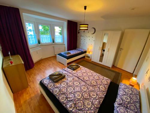 a bedroom with two beds and two windows at Ferienwohnung Augsburg 1 in Augsburg