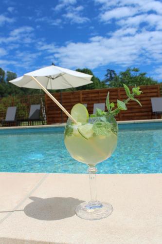 - une boisson assise sur une table à côté d'une piscine dans l'établissement Le Mas Charamèlia, à Saint-Victor-de-Malcap