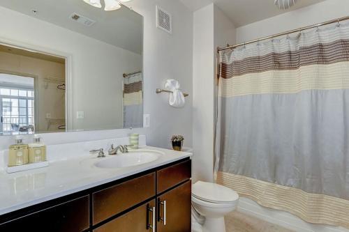 uma casa de banho com um lavatório, um WC e um espelho. em National at Clarendon em Arlington
