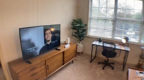 a living room with a large flat screen tv on a wooden entertainment center at National at Clarendon in Arlington