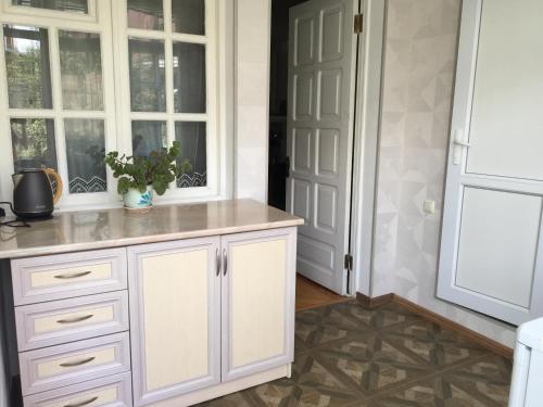 a kitchen with white cabinets and a door at Guest House Green Rose in Borjomi