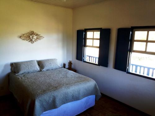 1 dormitorio con 1 cama y 2 ventanas en Sítio São Francisco - Um Refúgio Off-Road no Alto da Serra da Mantiqueira, en Delfim Moreira
