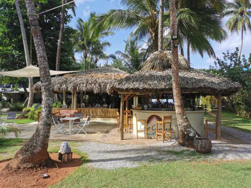 un restaurante con una cabaña de paja con palmeras en Casa Grande Hotel Restaurant, en Las Terrenas