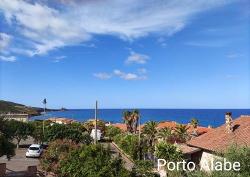 a view of the ocean from a town with houses at Alabe Hotel Marina di Tresnuraghes in Tresnuraghes