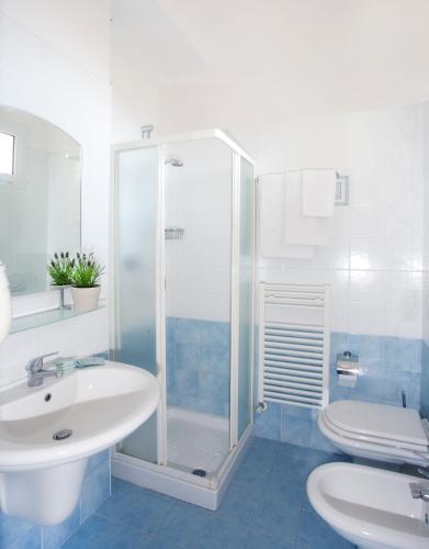 Un baño con ducha, lavabo e inodoro. en Hotel Fantasy, en Rímini