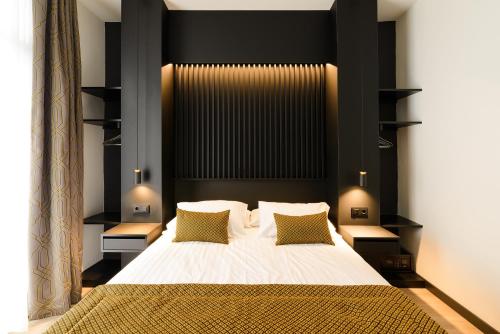 a bedroom with a large bed with black headboard at Elite Hotel - Gay Men Only in Sitges