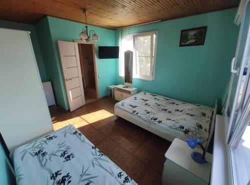 2 camas en una habitación con paredes azules en Guest House on Chernomorskaya Ulitsa, en Anapa