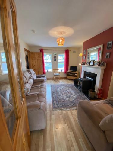sala de estar con 2 sofás y chimenea en Castlebaldwin Country Residence, en Sligo