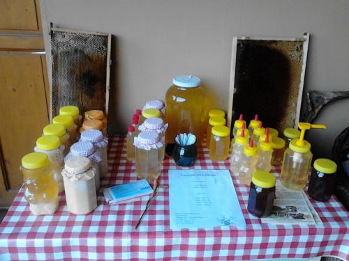 オリセントペーテルにあるEzerjó Ökofogadóの蜂蜜のボトルをたっぷりと入れたテーブル