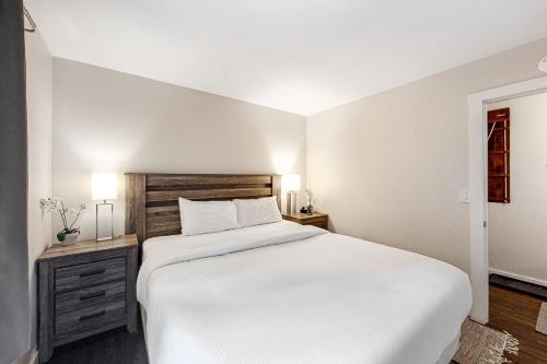 um quarto branco com uma cama grande e uma janela em Cozy Coyote Fork Condo em Truckee