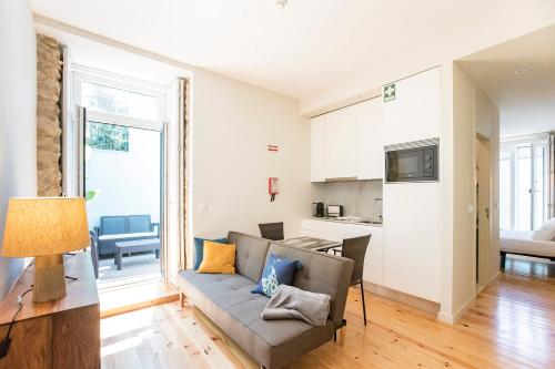 a living room with a couch and a kitchen at Central Studio with Pool & Patio by LovelyStay in Porto
