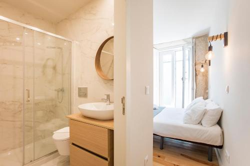 a bathroom with a sink and a toilet and a shower at Central Studio with Pool & Patio by LovelyStay in Porto