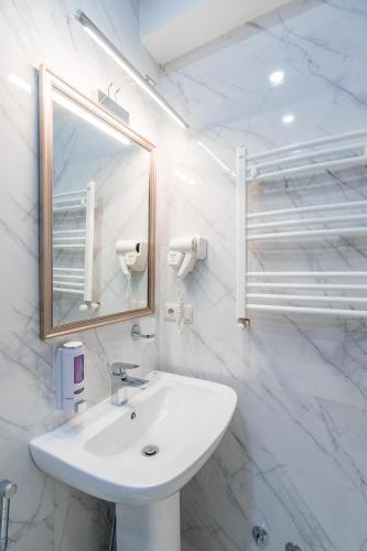 un bagno bianco con lavandino e specchio di Constant Tbilisi a Tbilisi City