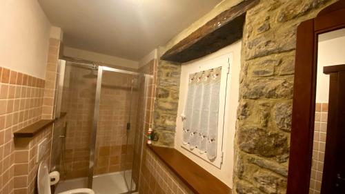 a bathroom with a shower and a toilet and a window at Agriturismo Il Casone in San Benedetto Val di Sambro