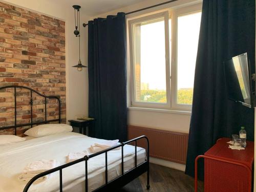 a bedroom with a bed and a brick wall at Art Hotel in Pykhtino