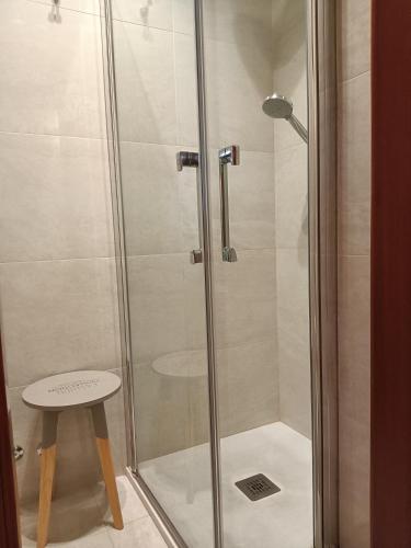 a shower with a glass door next to a stool at La Loggia Al Duomo - Treviso in Treviso