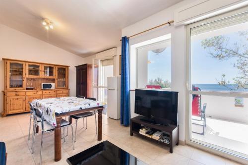 a living room with a table and a television at La terrazza di S'Oru 'e Mari in Quartu SantʼElena