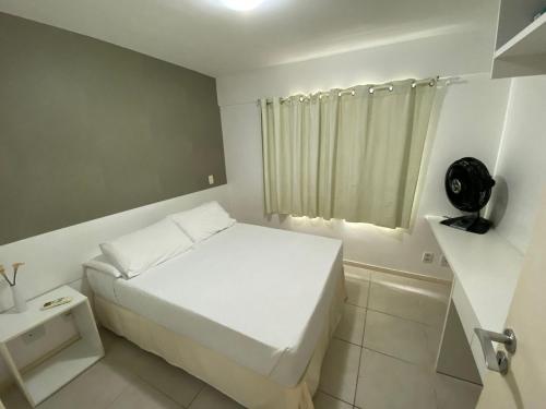 - une petite chambre avec un lit blanc et une fenêtre dans l'établissement Edifício JTR Torre México Apto 308 ER Hospedagens, à Maceió