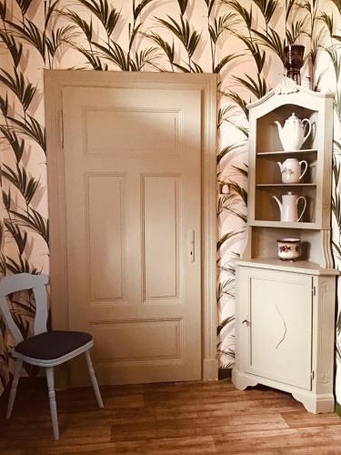 a room with a door and a chair and a shelf at Haus Claudia in Schneverdingen