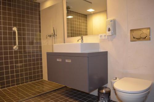 a bathroom with a sink and a toilet and a shower at Rembrandtplein Bed & Breakfast in Amsterdam