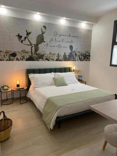 a bedroom with a bed with a poster on the wall at LOASI room&relax in Lecce